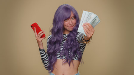 Happy young woman with lush wig looking smartphone display sincerely rejoicing win, receiving money...
