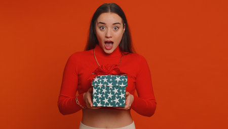 Happy pretty woman opening gift box, unwrapping birthday surprise and expressing great happiness...