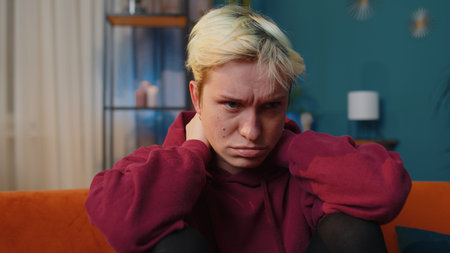 Displeased blonde woman rubbing temples to cure headache problem, suffering from tension and...