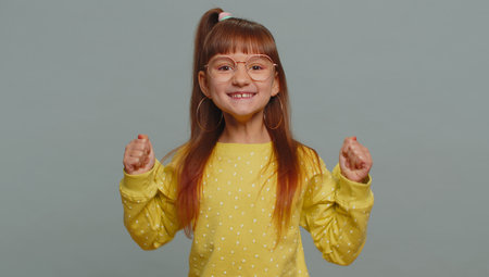 Young preteen child girl kid shouting, raising fists in gesture I did it, celebrating success,...