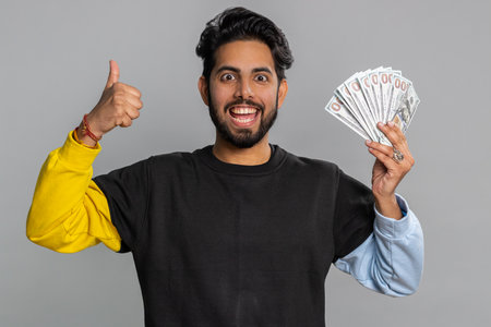 Rich pleased boss hindu man waving money dollar cash banknotes bills like a fan, success business...