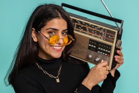 Indian woman using retro tape record player to listen music, disco dancing of favorite track, having...