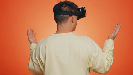 Man using headset helmet to play simulation game app online. Watching virtual reality 3D 360 video...