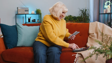 Planning budget. Rich senior woman counting money cash use calculator, calculate domestic bills at home. Elderly grandmother satisfied of income earnings win, saves money for planned vacation, giftsの写真素材