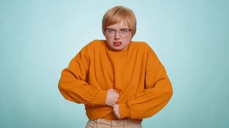 Young woman in sweater screams yell from stress tension problems feels horror hopelessness fear...