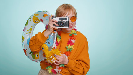 Happy woman tourist photographer in sunglasses taking pictures photos on retro camera. Travel,...