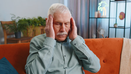Displeased senior grandfather man rubbing temples to cure headache problem, suffering from tension...