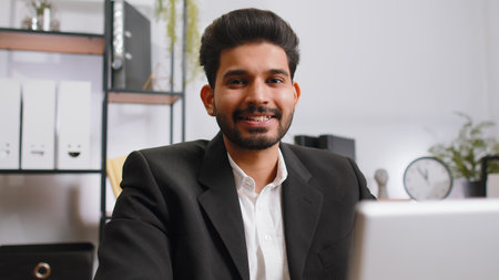 Close-up portrait indian bearded businessman face freelancer at home office workplace working on laptop computer. Manager freelancer indian man works on notebook send messages makes online purchasesの写真素材