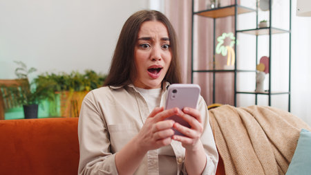 Sad displeased young woman use smartphone typing browsing, loses becoming surprised sudden lottery...