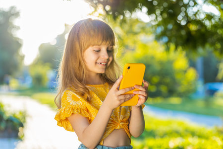 Preteen child kid using smartphone typing text answering messages chatting online looking mobile...