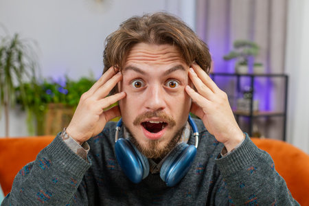 Oh my God Wow. Excited amazed Caucasian young man surprised looking at camera with big eyes shocked...