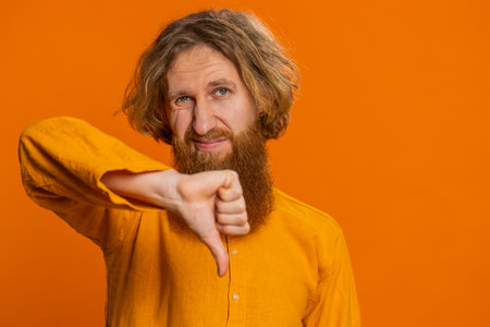 Dislike. Upset unhappy Caucasian man showing thumbs down sign gesture, expressing discontent,...