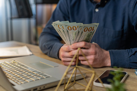 Close-up hands of businessman counting cash money dollar checking salary enjoy richness at modern...