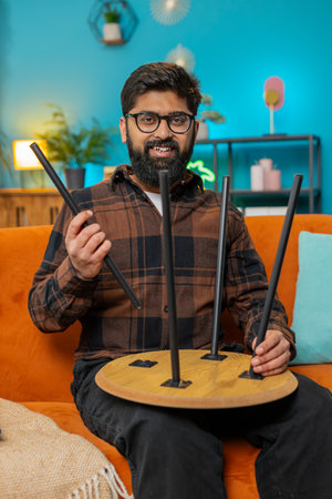 Happy Indian man finishing assembling furniture at home. Successful table desk collect, repair...