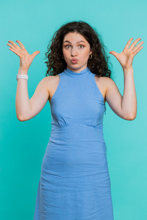 Amazed excited woman touching head and showing explosion, looking worried and shocked, celebrating success idea. Looking surprised of win wow girl isolated alone on blue studio background. Verticalの写真素材