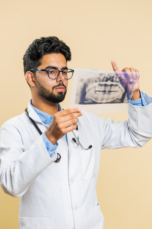 Indian young doctor orthodontist man examines a panoramic x-ray picture of the jaw teeth. 3D model...