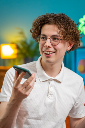 Happy Caucasian man making phone call conversation with friends at modern home room apartment. Young...