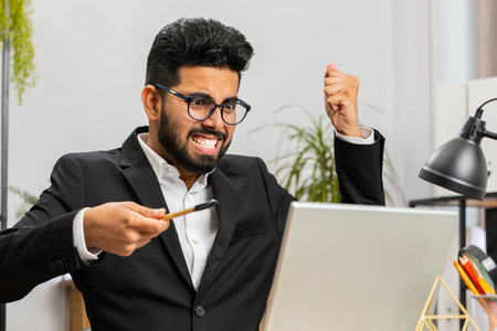 Conflict Quarrel Negotiation. Indian angry businessman CEO making webcam laptop online video call at office. Upset mad man talking colleague conversation analyzing financial report mistake problemの写真素材