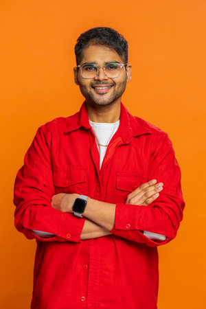 Cheerful happy young Indian man smiling friendly glad expression looking at camera dreaming resting...