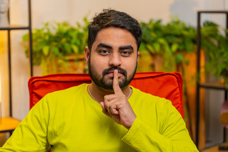 Shh be quiet please. Indian strict man presses index finger to lips makes silence hush gesture sign...