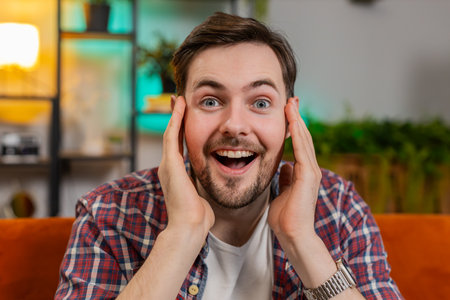 Portrait of amazed shocked man in plaid shirt with wow reaction open mouth looking at camera in...