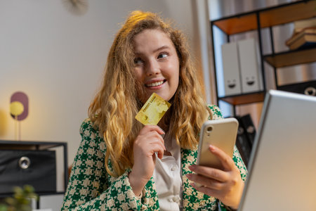 Happy Caucasian woman using bank credit card smartphone for online shopping payments at home office....