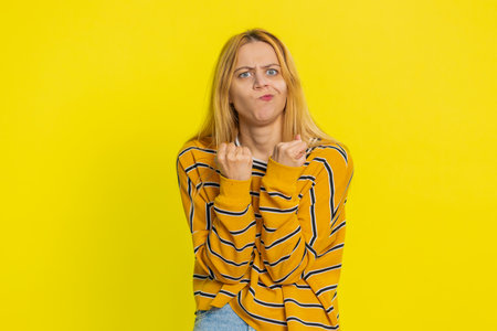 Upset frustrated annoyed Caucasian blonde woman raising hands in indignant expression, quarreling, asking reason of conflict, why such stubborn. Adult girl isolated on yellow backgroundの写真素材