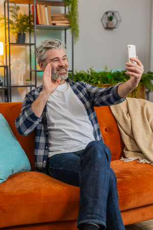 Senior man making video call with wave happy chat and communication on internet online app and...