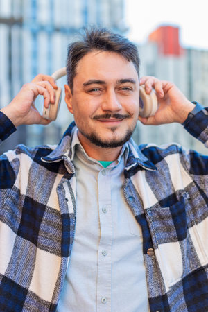 Joyful relaxed overjoyed mature bearded man listening favorite energetic disco rock n roll music...
