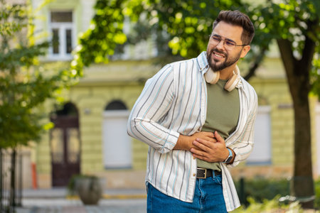 Caucasian young man traveler feeling sudden strong abdominal stomach ache gastritis problem. Upset...