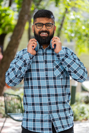 Indian bearded man tourist walking on urban city street outdoors in summer daytime. Guy traveler...