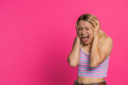 Irritated angry Caucasian young woman 30 years old screams from stress tension problems feels horror...
