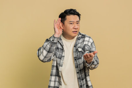I cant hear you. What. Asian middle-aged man trying hear you, looking confused and frowning, keeping...