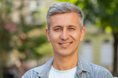 Portrait of happy mature man smiling friendly while standing glad expression looking at camera...