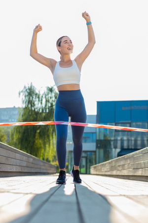 Athletic fitness sport runner girl finishing racing competition. Victory and success. Workout cardio...
