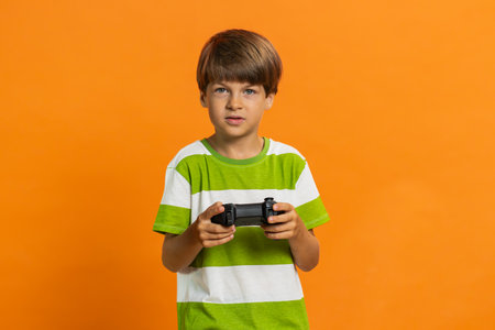 Young preteen child boy kid using joystick controller playing video console television game fun...