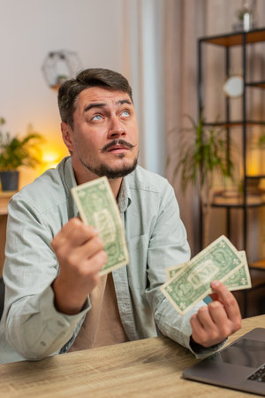 Caucasian man freelancer counting dollar cash insufficient amount of money. Financial crisis....
