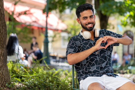 I love you. Indian young man makes symbol of love showing heart sign to camera, express sincere...