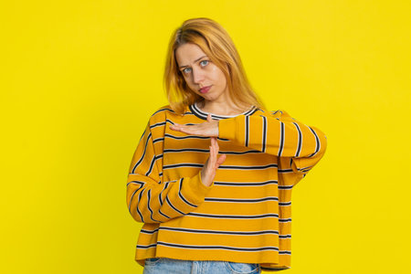 Tired serious upset Caucasian woman in blouse showing time out gesture, limit or stop sign, no...