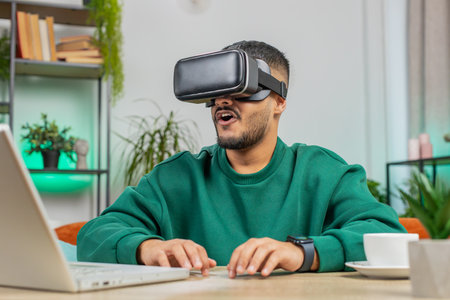 Indian man using virtual reality futuristic technology VR app headset helmet typing on virtual...