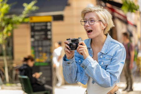 Caucasian young woman tourist traveling on weekends exploring town city, making photo pictures on...