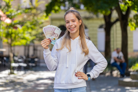 Successful rich Caucasian girl gambler gambling addiction business woman winner wins, holding fan of...