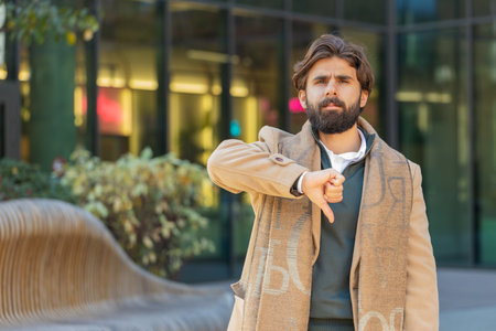 Dislike. Upset man showing thumb down sign gesture, expressing discontent disapproval, dissatisfied...