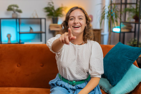 Young woman laughing out loud after hearing ridiculous anecdote, funny joke, feeling carefree amused, positive people lifestyle at home apartment. Attractive girl in living room on sofa. Lifestyles.の写真素材