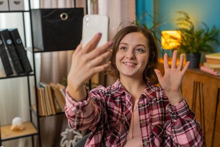 Hello. Happy Caucasian businesswoman waves hand hi gesture greeting welcomes someone on smartphone,...
