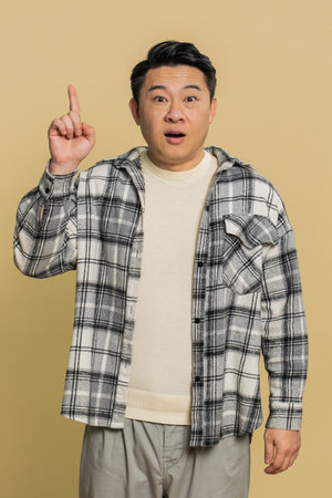 Good idea. Inspired Asian man pointing finger up with open mouth having plan, showing inspiration...