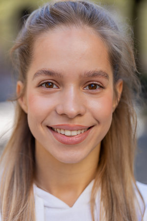 Closeup headshot portrait outdoors beautiful calm young woman looking at camera outdoors. Gorgeous...