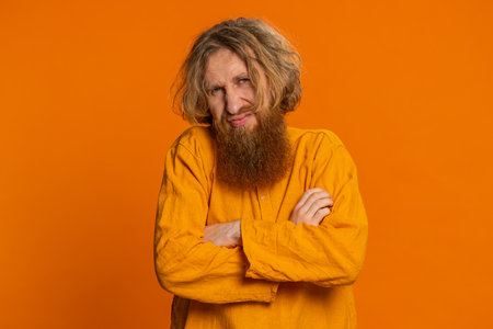 Redhead Caucasian man feeling hopelessness, loneliness, nervous breakdown, bad fortune, loss, and unlucky news. Bearded guy isolated on orange backgroundの写真素材