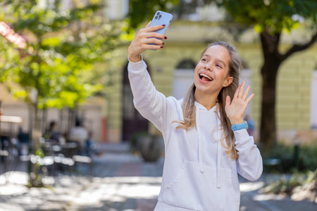 Caucasian joyful woman walking city attractions street outdoors, talking video chat chatting phone call smartphone vlog tourism travel looking at camera online smiling girl distant vacations trip.の写真素材