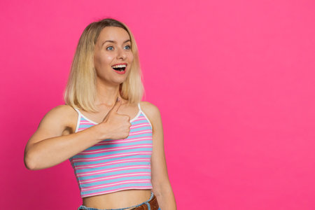 Like. Caucasian woman raises thumbs up agrees with something or gives positive reply recommends advertisement likes good idea feedback celebrating success victory. Girl isolated on pink backgroundの写真素材